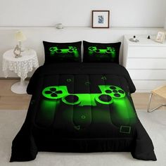 a bed covered in black and green comforters with video game controllers on it's side