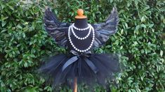 a mannequin wearing a black tutu and pearls