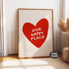 a red heart with the words our happy place on it in front of a white wall