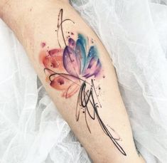 a watercolor butterfly tattoo on the right arm and leg, it is painted with multi - colored inks