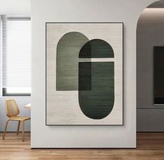 an abstract painting hangs on the wall next to a chair in a modern living room