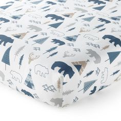 a baby crib sheet with bear and pine trees on the bottom in blue, grey, and white