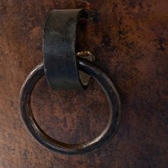 a close up of a metal object with a ring on it's end and a chain hanging off the side