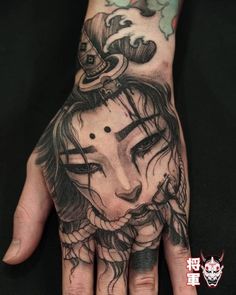 a person's hand with a tattoo on it and a woman's face