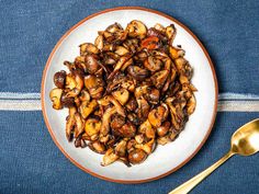 a white plate topped with cooked mushrooms on top of a blue cloth