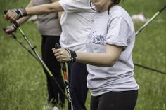 three women holding skis and poles in the grass