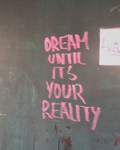 graffiti on the side of a building reads dream until it's your reality