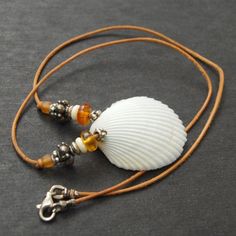 two seashells are sitting on a brown cord