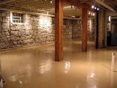 an empty room with exposed ceiling and stone walls