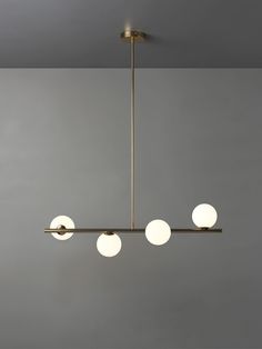 three lights hanging from the ceiling in a room with gray walls and grey flooring