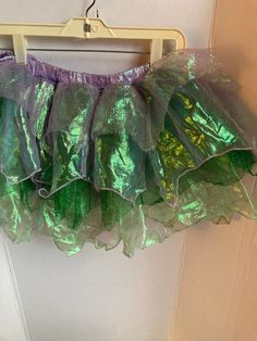 a green and purple skirt hanging on a door