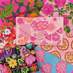 several different types of purses and wallets on a pink background with orange slices