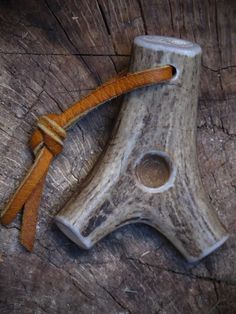 an old wooden object with leather straps on it's sides and a piece of wood in the middle