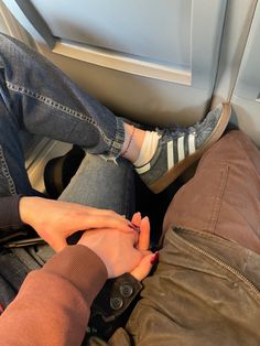 two people holding hands while sitting on the floor in front of a door with their feet up