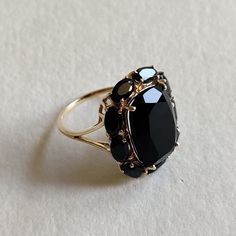 This stunning ring is set in 14k Solid Yellow Gold with Natural Black Onyx with utmost precision. It is a unique statement gemstone ring for nearly every occasion and is completely hassle-free jewelry. ITEM DETAILS: * CENTER GEM: Black Onyx * GEM SIZE: 10X14mm * GEM SHAPE: Cushion * SIDE GEM: Black Onyx * GEM SIZE: 3x5mm (9 pcs) * GEM SHAPE: Oval * Total Gem weight: 8.85 carats * Gold Purity: 14KT (58.33% approx.) * Gold Weight: 2.41 gram * Total Weight of the Ring: 4.18 gram The Gold purity is guaranteed and it comes with authentic 14KT gold hallmark. Since my items are handmade, they are absolutely nickel and lead free. CUSTOMIZATION: * Size Customization is available for this ring and it is available in all ring sizes. Kindly choose your ideal ring size from the drop-down. * Gemstone cu Black Victorian Rings With Polished Finish, Victorian Black Rings With Polished Finish, Victorian Style Black Rings With Polished Finish, Classic Black Oval Sapphire Ring, Classic Black Sapphire Oval Ring, Black Heirloom Jewelry With Polished Finish, Heirloom Black Polished Finish Jewelry, Black Oval Cluster Ring For Anniversary, Black Sapphire Ring With Polished Finish For Anniversary