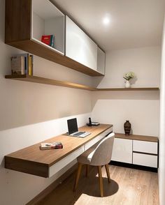 a desk with a laptop computer on top of it next to a book shelf and shelves