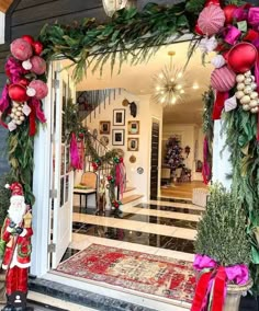 christmas decorations are displayed in front of the entrance to a home decorated with red and green ornaments