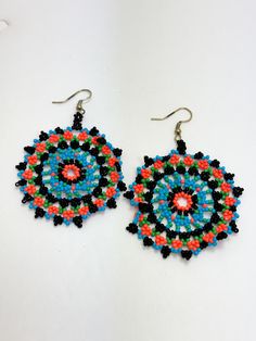 Beaded disc earrings. Lightweight. Colors: Turquoise, black, orange, and green. Size: 2.25 Black Beaded Drop Earrings With Large Beads, Black Large Beaded Drop Earrings, Multicolor Beaded Round Earrings For Festivals, Turquoise Earrings With Black Round Beads, Multicolor Round Beaded Earrings, Black Earrings With Large Round Beads, Multicolor Circular Beaded Earrings With Ear Wire, Multicolor Beaded Circle Earrings, Black Earrings With Colorful Beads