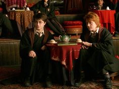 two harry potters sitting at a table in front of some other hogwart's