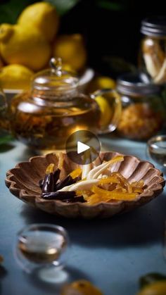 a table with lemons, tea and other food items on it's surface