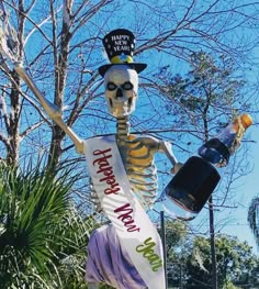 a skeleton holding a bottle and wearing a top hat with the words happy new year on it