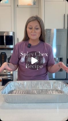 a woman standing in front of a pan filled with food and holding her hands out