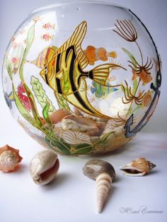 a glass bowl filled with sea shells and fish