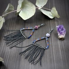 I was so inspired by the shapes and colors in the salt mountains in Iran. I decided to replicate them in a pair of triangle hoop earrings. To pull out some of the colors, I used 8mm starcut lightning agate, 3mm faceted sapphires, and 3mm hessonite garnet. The fringe on the bottom is black nylon-coated steel beading wire. It is stiff, yet not scratchy so it will hold the fun flare but not scratch you.Each earring is about 3.75” long and weighs 3.85g. The earrings are constructed from sterling sil Unique Dangle Hoop Earrings With Natural Stones, Bohemian Dangle Earrings With Faceted Details, Bohemian Adjustable Triangle Earrings, Bohemian Triangle Adjustable Earrings, Adjustable Bohemian Triangle Earrings, Bohemian Triangle Earrings With Ear Wire, Handmade Triangle Bohemian Jewelry, Handmade Bohemian Triangle Jewelry, Handmade Triangle Earrings For Festival