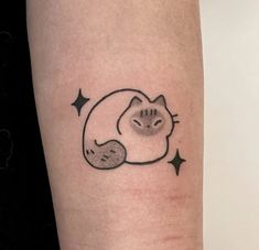 a small cat tattoo on the left inner arm and leg, with stars around it