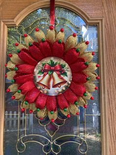 a christmas wreath with bells hanging from it's side on a wooden door frame