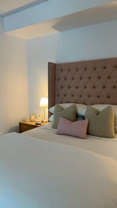 a large bed with white sheets and pillows