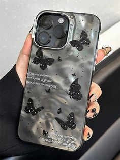 a woman holding an iphone case with butterflies on it