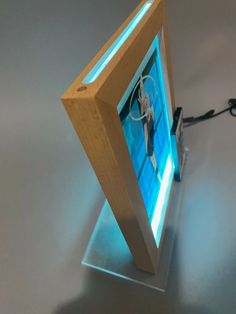 a small wooden object with a blue light on it's side and a wire running through the middle