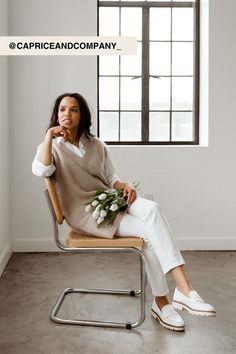 a woman sitting in a chair with flowers on her lap