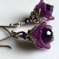 "Adorable and sweettiny amethyst tulips from my \"Bouquet of Flowers\" collection These precious little tulips are designed from dark amethyst colored Swarovski crystals capped with beautiful acrylic tulips. Layers of ornate leafy beadcaps in antique sterling silver plate add that perfect touch of detail. These diminutive drops hang a mere 5/8\" (14mm) from oxidized sterling silver French earwires. Prefer a different style of earwires? Non pierced clips in antique silver plate, leverbacks and ki Purple Pierced Earrings For Wedding, Elegant Purple Flower Earrings For Party, Purple Drop Crystal Earrings For Gifting, Purple Drop Crystal Earrings As Gift, Purple Crystal Drop Earrings For Gift, Purple Flower-shaped Jewelry For Weddings, Dainty Nickel-free Purple Earrings, Dainty Purple Nickel-free Earrings, Purple Pierced Crystal Earrings As Gift