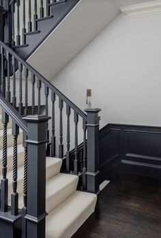 an empty staircase with white carpet and black railings