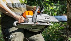 a man is holding a chainsaw in his hands