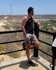 a man standing on top of a metal rail next to a woman in black shirt