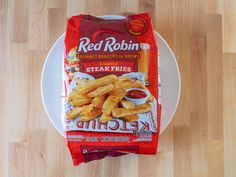 a bag of red robin steak fries sitting on top of a white plate