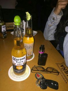 two bottles of beer sitting on top of a table