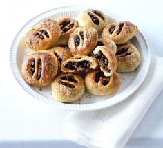 a white plate topped with pastries on top of a table next to a napkin