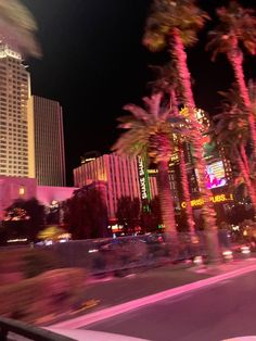 palm trees are lit up at night in las vegas, nv as seen from a moving vehicle