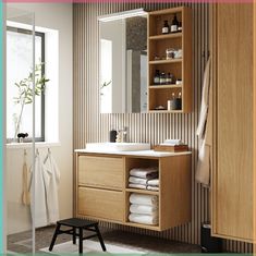 a bathroom with wooden cabinets and white towels on the shelf next to it is also a mirror