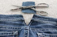 pair of scissors and jeans lying on the floor next to it's cutout