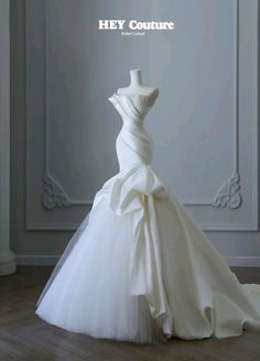 a wedding dress on display in front of a white wall with the words hey couture