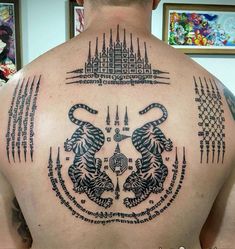 the back of a man with tattoos on his body