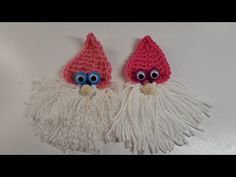 two crocheted gnomes with blue eyes and white hair