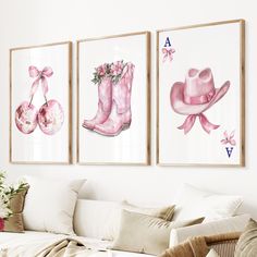 three pink boots and hats are hanging on the wall above a couch in a living room