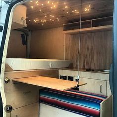 the inside of a van with a bed and desk