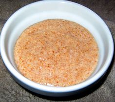 a white bowl filled with food sitting on top of a brown cloth covered tablecloth